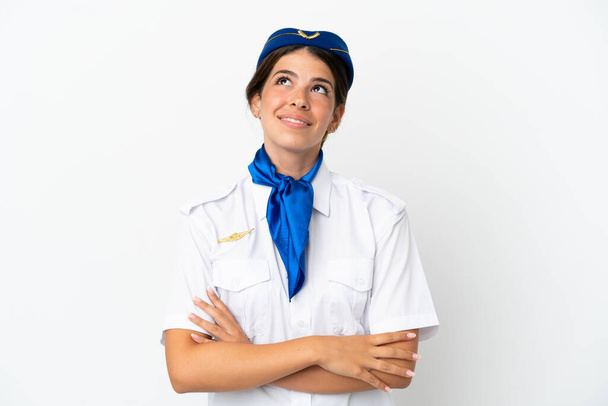 Stewardess kaukasischen Frau isoliert auf weißem Hintergrund Blick nach oben, während lächelnd - Foto, Bild