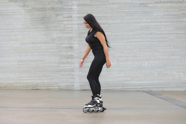 young beautiful woman in sportswear on roller skates - Foto, afbeelding