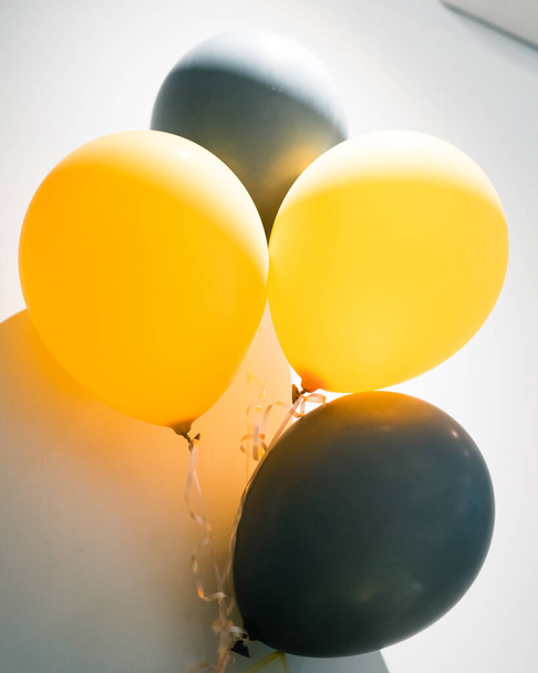 Koncepcja uroczystości i uroczystości z żółtymi i szarymi balonami na białym tle. - Zdjęcie, obraz