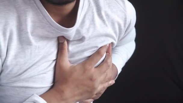 jonge man lijden pijn in het hart en houden borst met de hand  - Video