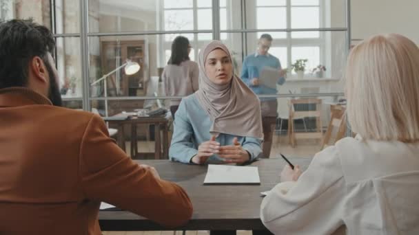 Střední záběr, jak zástupci HR mluví s muslimskou zaměstnankyní a říkají jí, že ji propouštějí. Zpívá dokument a frustrovaně odchází. - Záběry, video