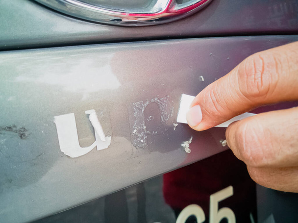 Remove the adhesive letter from the car body. - Photo, Image
