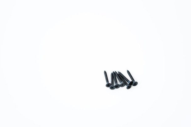 Tornillos negros de tornillos autorroscantes de los mismos tamaños aislados sobre fondo blanco. - Foto, imagen