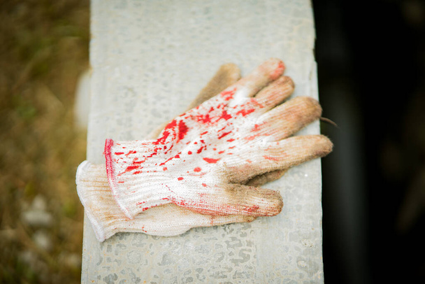 Gants de viande avec taches de sang sur le béton. - Photo, image