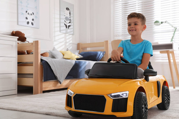 Cute little boy driving big toy car at home - Zdjęcie, obraz
