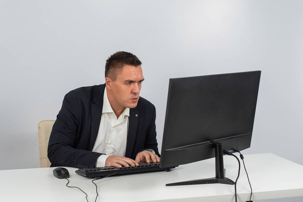 caucasian man working at the computer on a white background. - Foto, afbeelding