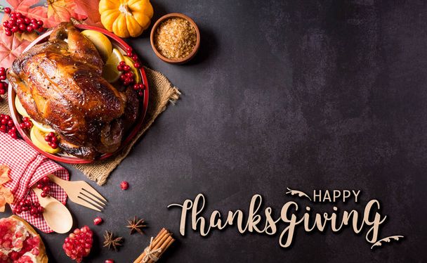 Thanksgiving dinner background concept with turkey roasted and all sides dishes, fall leaves, pumpkin and seasonal autumnal decor with the text on dark stone background. - Foto, Imagem