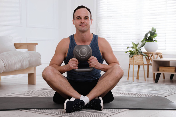 Muscular man training with kettlebell at home - Foto, Imagem