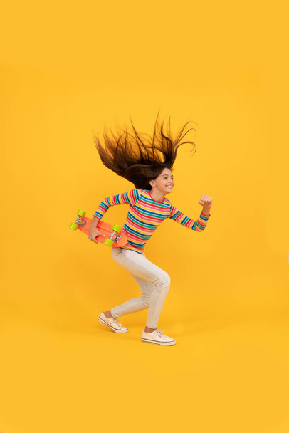 energetic kid skateboarder in colorful clothes. penny skateboard. skateboarding. - Zdjęcie, obraz