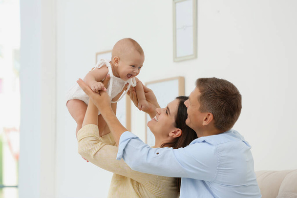 Portrait of happy family with their cute baby at home - Foto, Imagem