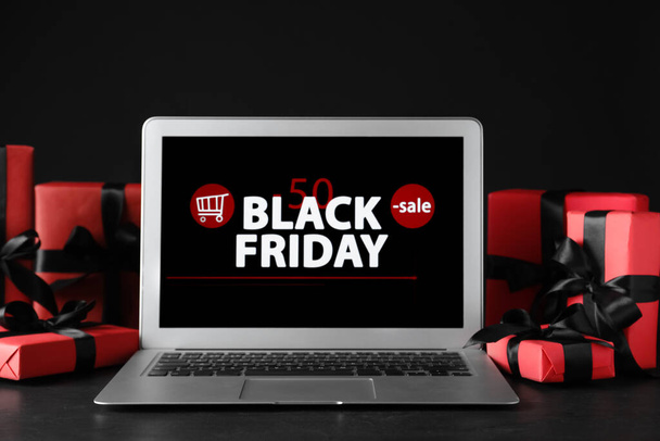 Laptop and gift boxes on table. Black Friday sale - Foto, Imagem
