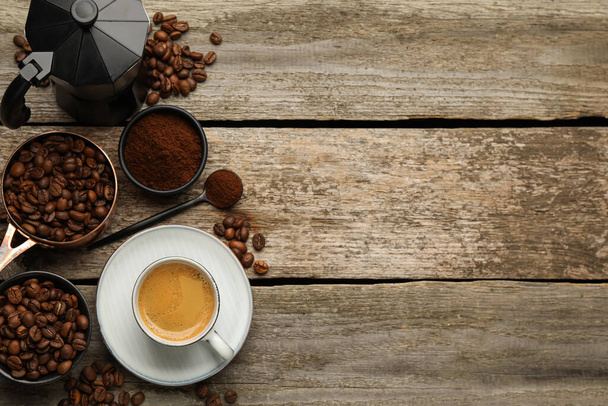 Coffee maker, beans, powder and cup of drink on wooden table, flat lay. Space for text - Fotografie, Obrázek
