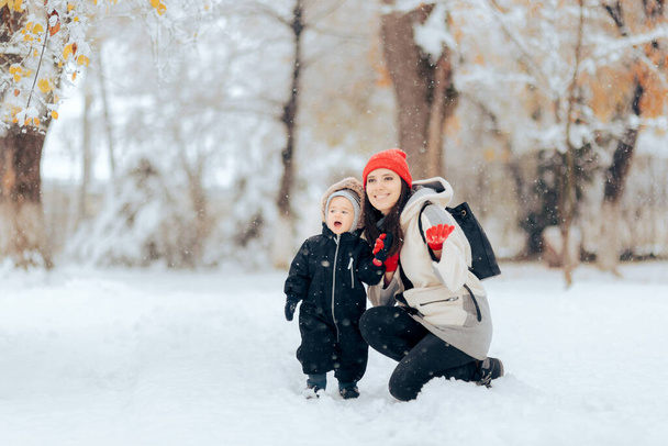 Mother and Daughter Admiring Snow Falling in Winter Season - Photo, image