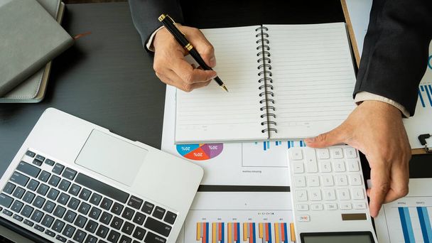 İş adamları grafikleri analiz etmek ve raporları, şirket finans bütçelerini ve başarılı bir iş konsept ofisinde gelecek için plan yapmak için dizüstü bilgisayar ve hesap makinesi kullanırlar.. - Fotoğraf, Görsel