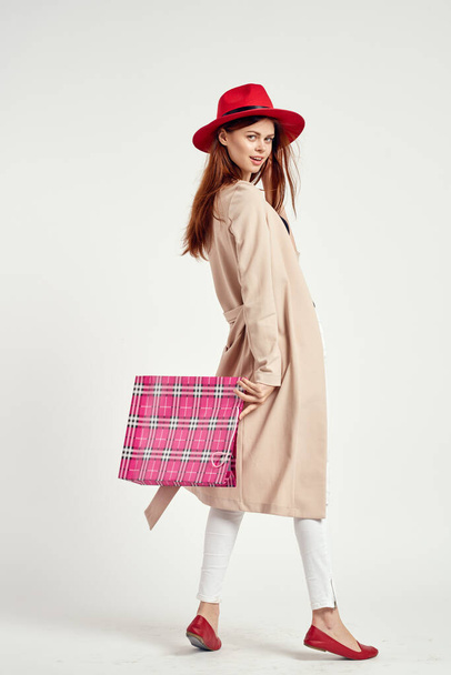 cheerful woman wearing a red hat posing shopping fun light background - Valokuva, kuva