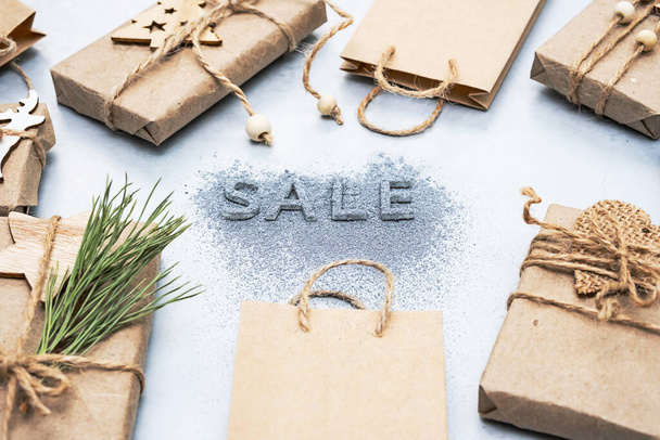 Inscription - Sale, gift boxes and brown paper bags, flat lay, copy space. Winter holiday or seasonal sales. Online sale or clearance store, promotion, discounts. - Photo, Image
