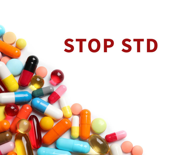Different pills and text STOP STD on white background, top view - Foto, Imagem