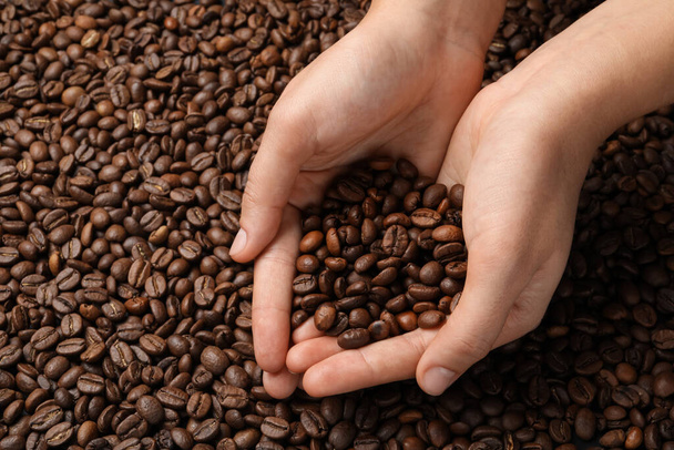 Woman with roasted coffee beans, closeup. Space for text - Photo, Image