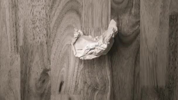 Stop motion animaatio paperi ryppyjä tehdä paperi pallo ja leviää tehden tyhjä arkki puinen tausta. - Materiaali, video