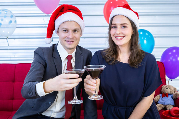 Happy new year 2022 concept,Happy couple of wrist in a business suit holding glasses of Clinking Champagne in Christmas and New Year's Eve party After finishing business work - Foto, imagen