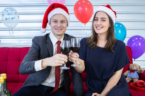 Ευτυχισμένο το νέο έτος 2022 έννοια, Ευτυχισμένο ζευγάρι κρατώντας ποτήρια Clinking σαμπάνια στα Χριστούγεννα και την παραμονή της Πρωτοχρονιάς κόμμα Μετά την ολοκλήρωση των εργασιών των επιχειρήσεων  - Φωτογραφία, εικόνα