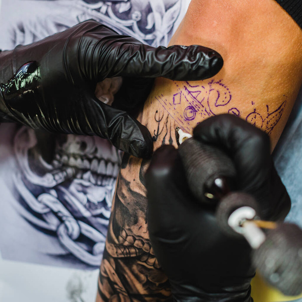 guanti mani facendo tatuaggio. Foto di alta qualità - Foto, immagini