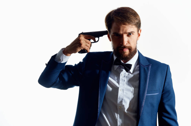 Mann im Anzug mit Pistole in der Hand heller Hintergrund - Foto, Bild