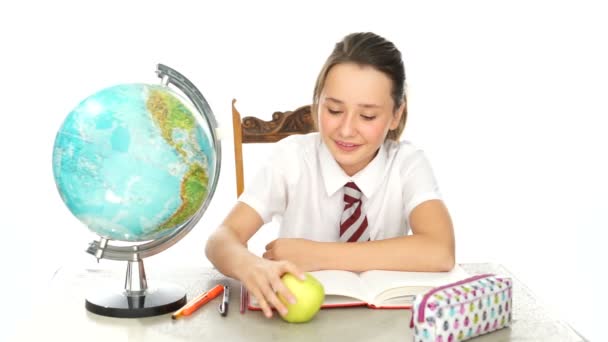 Happy healthy young girl eating an apple in class - Materiał filmowy, wideo