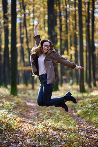 Portrait of a young attractive caucasian woman in an oak forest during autumn - Foto, afbeelding