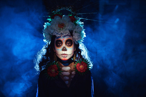 Femme avec un crâne mexicain maquillage d'Halloween sur son visage. Jour des morts et Halloween - Photo, image
