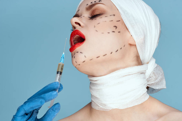 woman posing in blue gloves red lips surgery facial rejuvenation blue background - Fotoğraf, Görsel