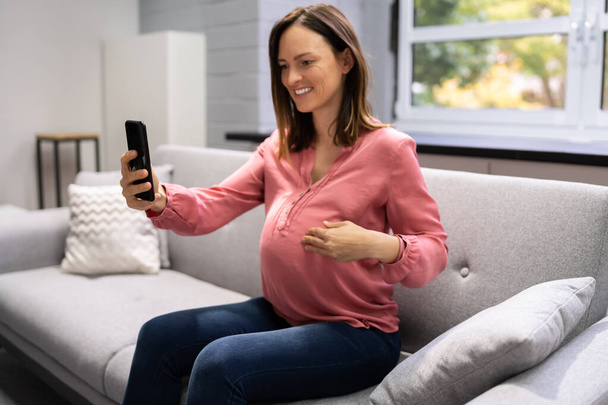 Mujeres embarazadas Médico videollamada en el teléfono en casa - Foto, imagen