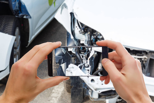Hombre fotografiando su vehículo con daños para el seguro de accidentes con teléfono inteligente
 - Foto, Imagen