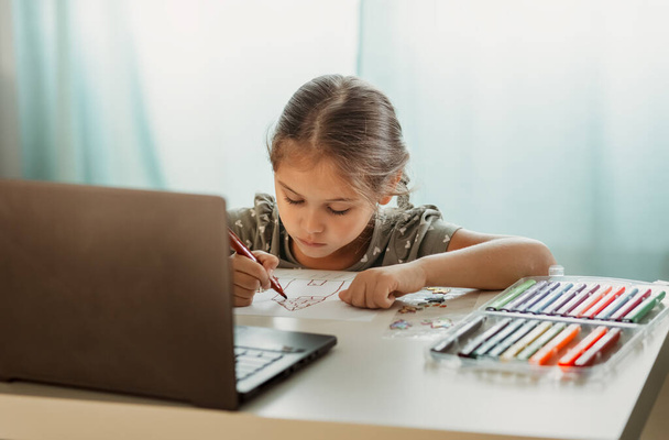 Mała dziewczynka rysuje przed ekranem komputera. Lekcje rysunku online - Zdjęcie, obraz