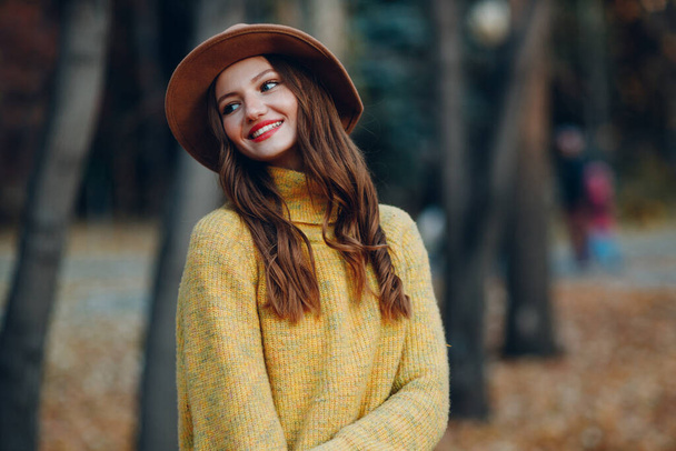 Modelo de mulher jovem no parque de outono com folhas de bordo de folhagem amarela. Moda de estação de outono. - Foto, Imagem