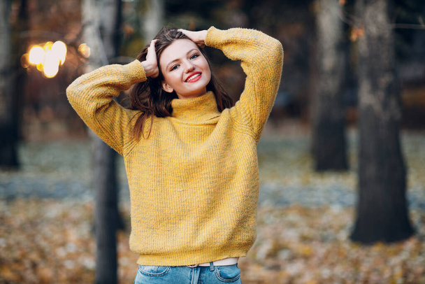 Молодая женщина модель в осеннем парке с желтыми листьями клена. Мода осеннего сезона. - Фото, изображение