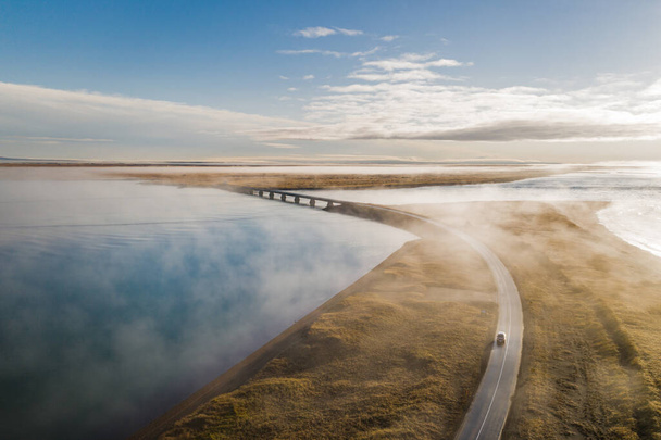 The car road over the lake on a foggy day in Iceland - Фото, изображение