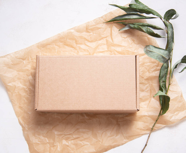 Brown Cardboard Carton box on fresh green leaves - Foto, afbeelding