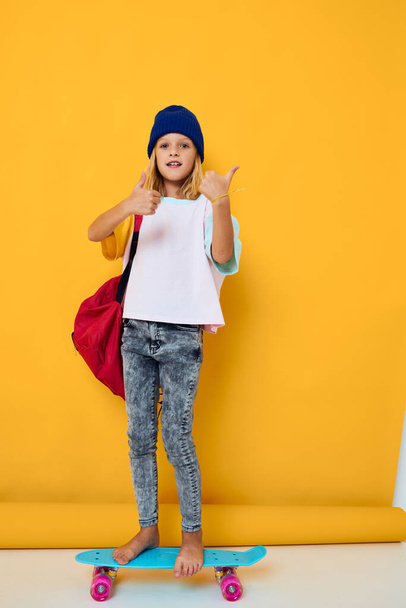 портрет дівчини в білій футболці, що позує зі скейтбордом в руці концепція дитячого способу життя
 - Фото, зображення