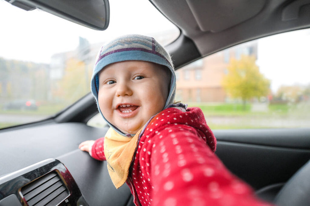 Onnellinen söpö poikavauva sähköauton sisällä. Perheauto - Valokuva, kuva