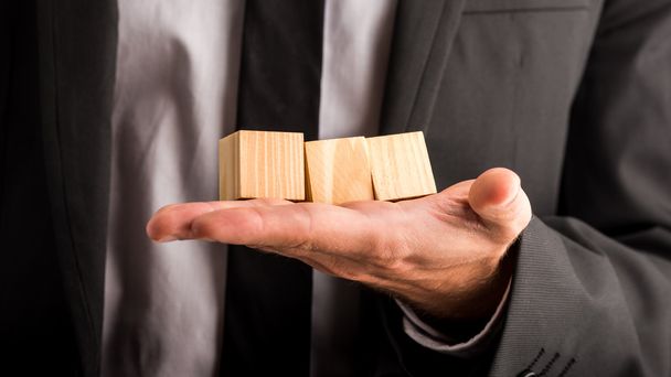 Businessman holding three blank wooden cubes - Photo, image