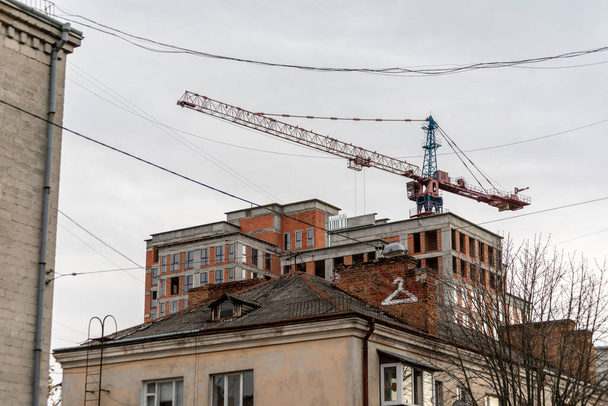 Construction crane on the construction of the house. A new neighborhood of the city, where new housing is being built. - Zdjęcie, obraz