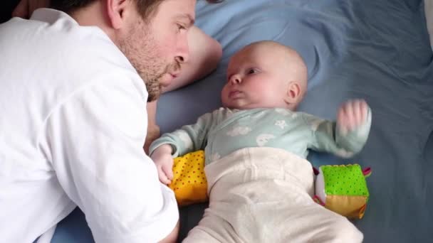 Vater unterhält sich mit seinem Baby beim Spielen, verbringt Zeit miteinander - Filmmaterial, Video