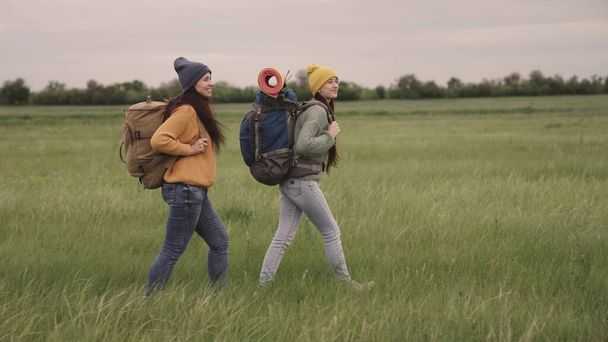 Щасливі дівчата подорожують з рюкзаками, веселі вихідні з туристичними сумками, активний спосіб життя на відкритому повітрі, відпочинок жіночої групи, подорожуючі хіпстером протягом тисяч років, вільний рух у пошуках
 - Фото, зображення