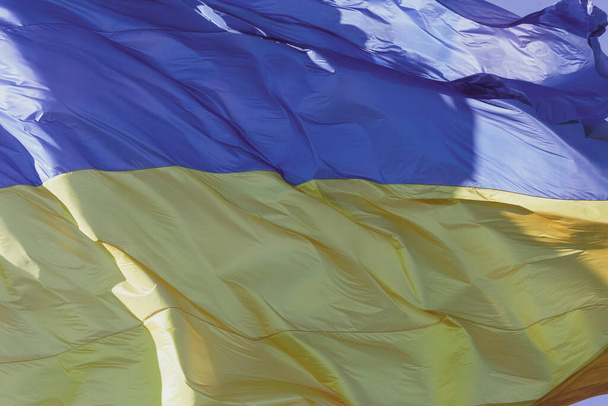 Le drapeau jaune et bleu de l'Ukraine sur le mât flotte dans le vent - Photo, image