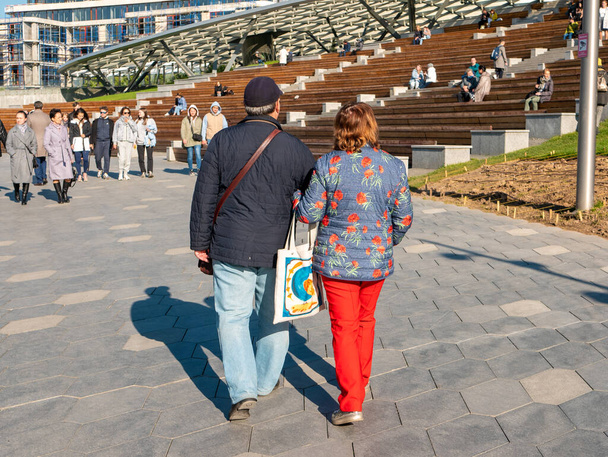Moscú, Rusia - 5 de octubre de 2021: Zaryadye Park. La gente camina cerca del gran anfiteatro de la sala de conciertos Zaryadye en un día soleado de otoño. - Foto, Imagen