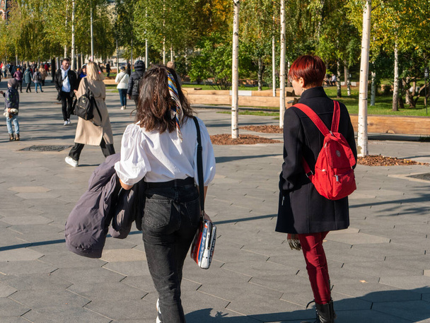 Moskova, Venäjä - 5. lokakuuta 2021 Zaryadye Park. Tytöt kävelevät puiston polkua pitkin aurinkoisena syyspäivänä.. - Valokuva, kuva