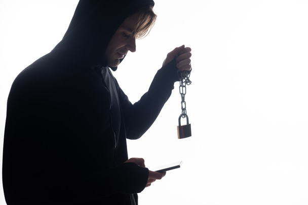 Side view of hacker using smartphone and holding padlock isolated on white  - Photo, Image