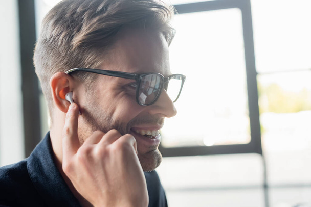 Fröhlicher Entwickler im Kopfhörer hört Musik im Büro  - Foto, Bild
