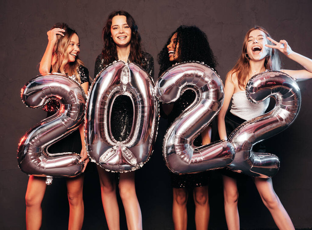 Beautiful Women Celebrating New Year.Happy Gorgeous Female In Stylish Sexy Party Dresses Holding Silver 2022 Balloons, Having Fun At New Year's Eve Party. Holiday Celebration.Charming Models  - Foto, Bild